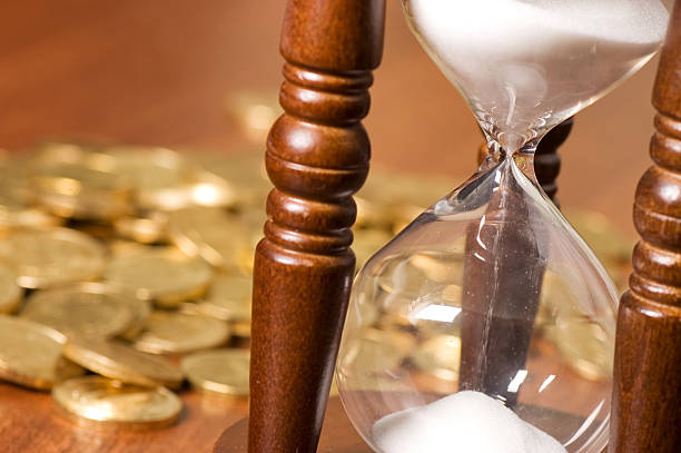 istock Hourglasses and coin On a wooden table 120640884