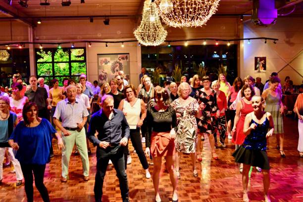 Workshop classes. Indoor line dancing by a professional instructor. Herent, Belgium - September 14, 2019: Open House indoor dancing classes evening show. Photo reportage open door promotion indoor dance classes. Courses starting half September. Teacher in front of group demonstrates solo dance. teacher retirement party stock pictures, royalty-free photos & images