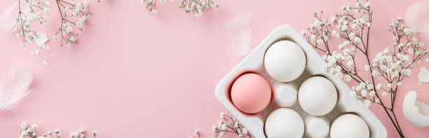 istock Easter eggs in white ceramic holder and flowers on pink background 1206410159