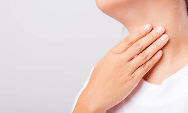 istock Asian beautiful woman Sore Throat or thyroid gland problem her useing Hand Touching Ill Neck on white background 1206411714
