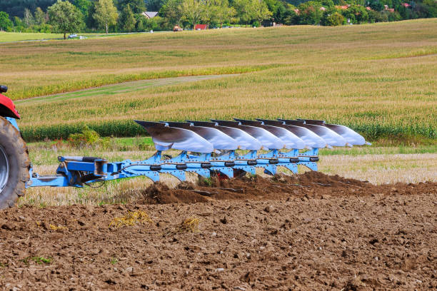 istock Farmer in red tractor preparing land with plow for sowing 1206412434