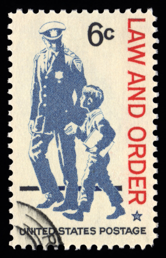 USA vintage postage stamp law and order showing a police officer assisting a young child
