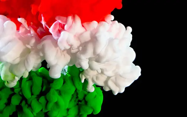 Photo of Flag of Hungary made of color ink on a black background. Red, white and green watercolor ink in water.