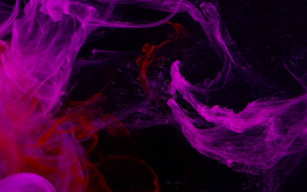 istock Pink watercolor ink in water on a black background. Colored space magic background 1206414654