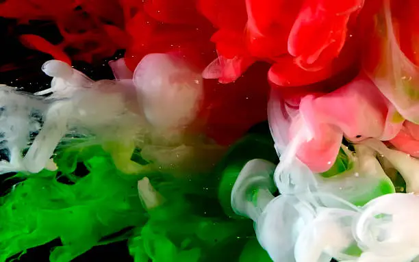 Photo of Flag of Hungary made of color ink on a black background. Red, white and green watercolor ink in water.