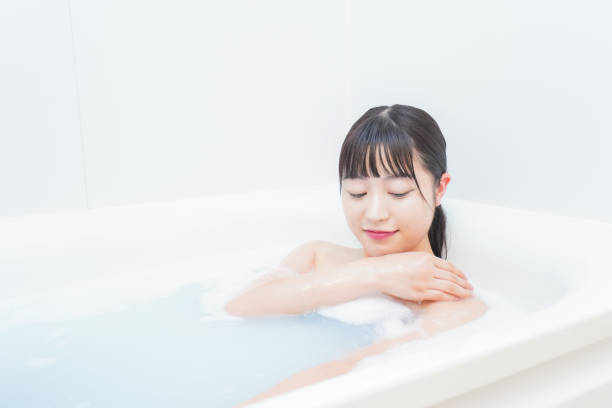 giovane donna nella vasca da bagno - bathtub asian ethnicity women female foto e immagini stock
