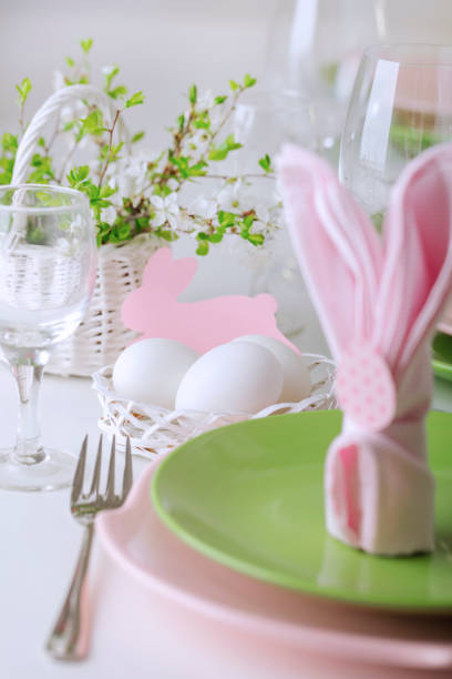istock Happy easter. Decor and table setting of the Easter table is a vase with pink tulips and dishes of pink and green color. 1206424034