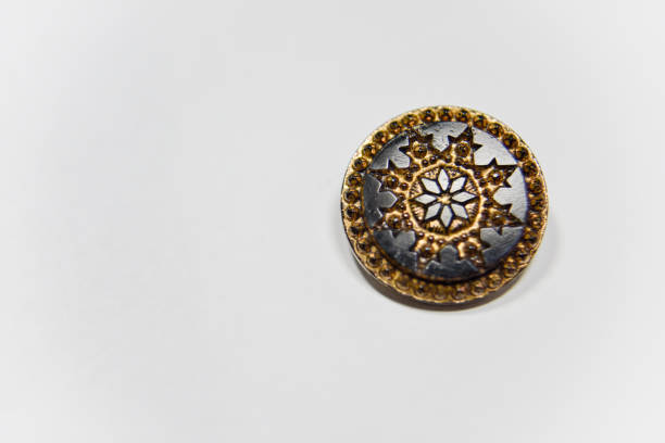 Black and golden ornamented button with floral mandala pattern on the front side. Selective focus, handcraft concept.