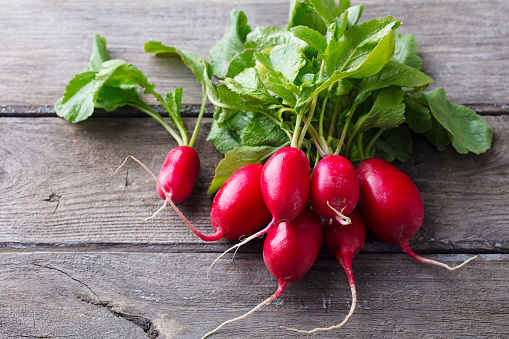 Radish bunch on rustic wooden background. Close up.