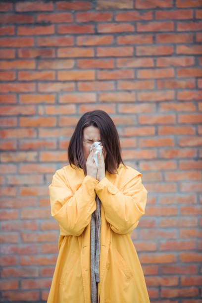 istock Sick young woman blowing her nose 1206425504