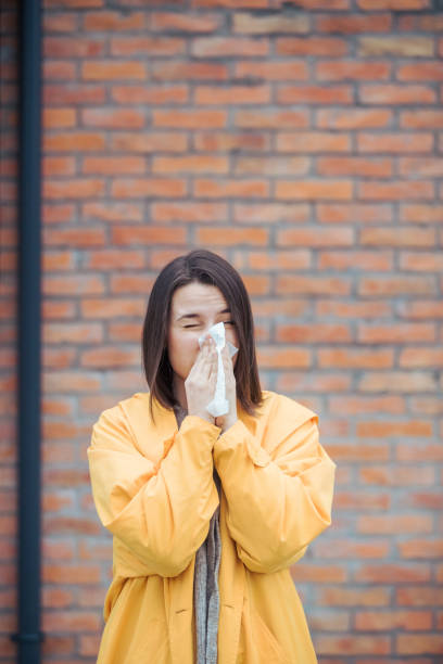 istock Sick young woman blowing her nose 1206425510