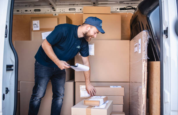 istock Smiling Male Delivery Driver Checking Loaded Packages 1206427194