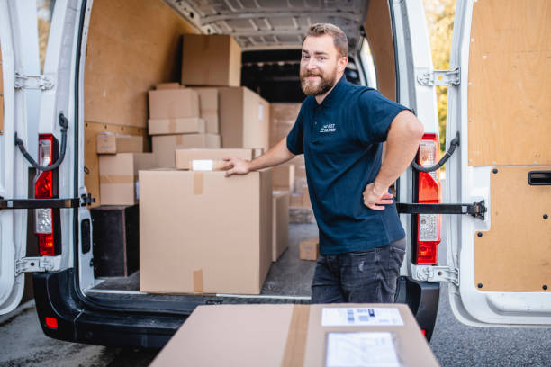 istock Smiling Male Delivery Expert Loading Parcels onto Van 1206427213