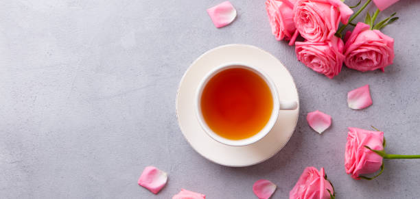 istock Cup of tea with pink rose. Grey stone background. Top view. Copy space. 1206428321