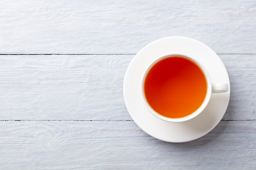 Cup of tea on a grey wooden background. Copy space. Top view.
