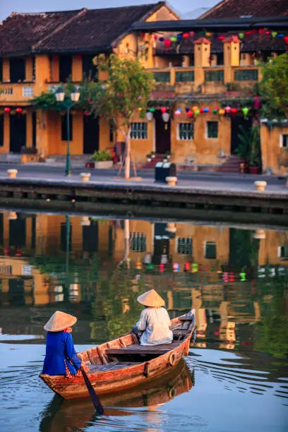 Photo of Vietnamese women riding a boat, old town in Hoi An city, Vietnam