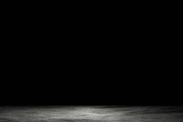 istock Light shining down on dirt gray cement floor in dark room with copy space, abstract background 1206436283