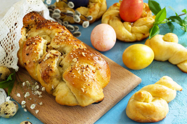 istock Traditional Italian Easter bread rings. Easter sweet bread with colored eggs on a blue stone concrete tabletop. 1206436842
