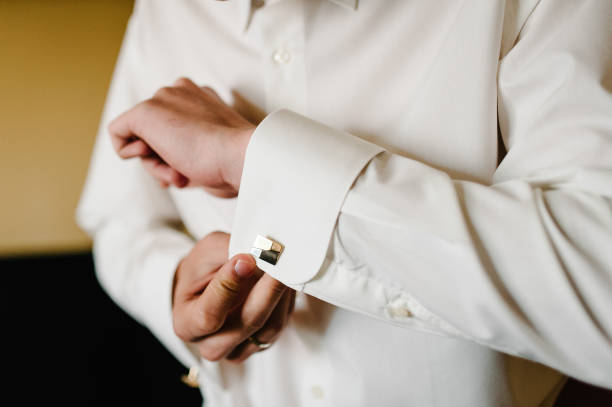 istock Hand's groom wears a metallic silver cufflinks stud. Wedding morning. 1206437886