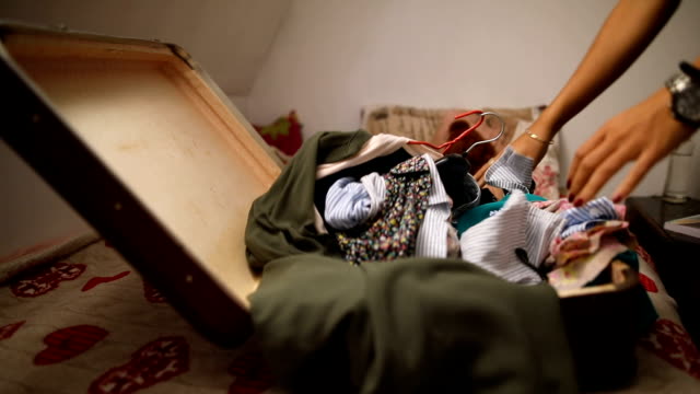 Young woman packs a suitcase for the trip in her room