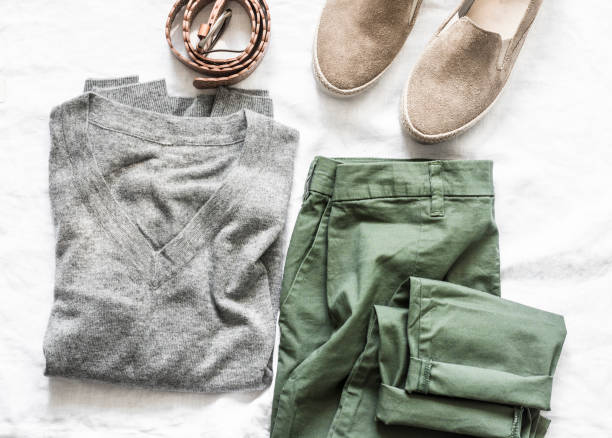 istock Women's clothing on a light background, top view. Suede shoes, grey pullover, pant, belt clothing for walking. Fashion concept, flat lay 1206440968