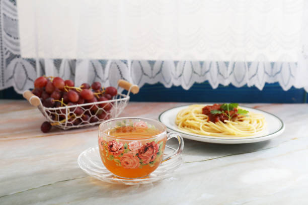 Delicious spaghetti and a cup of tea on the dining table