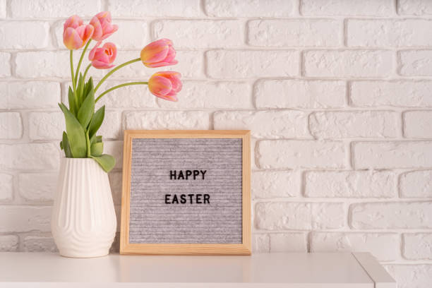 istock vase with tulips and gray felt letter board with words Happy Easter on white bricks background 1206448617