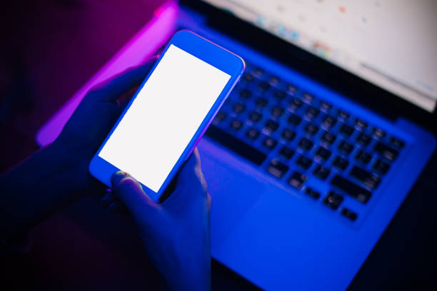 istock Top view of using smartphone in purple neon light 1206455917
