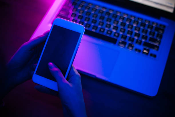 istock Top view of using smartphone in purple neon light 1206455945