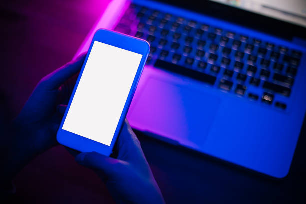 istock Top view of using smartphone in purple neon light 1206455948