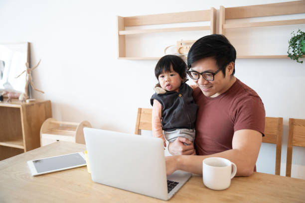 istock Father using laptop with baby boy at home 1206459014