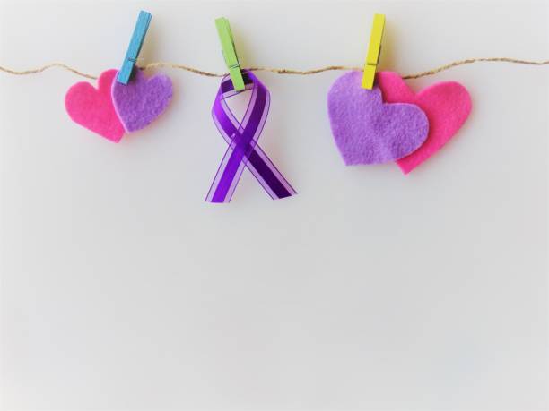紫色のリボン。心、物干しに固定 - 認知月間:膵臓癌、てんかん、アルツハイマー病、肺素、家庭内暴力、動物虐待、クローン病、嚢胞性線維症、線維筋痛症、サルコイドーシス、甲状腺癌、 - social awareness symbol 写真 ストックフォトと画像