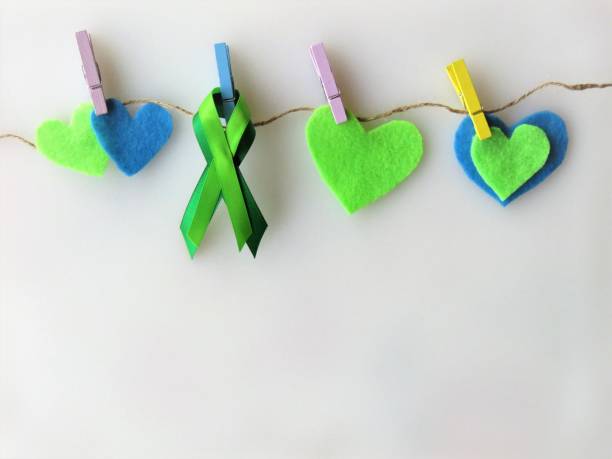 ruban vert, cœurs, épinglé à la corde à linge--mois de sensibilisation: lymphome non hodgkinien; santé mentale - hodgkins disease photos et images de collection