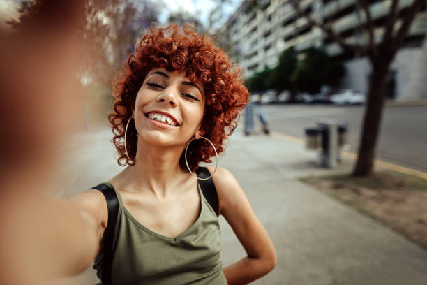 istock Redhead Latin woman taking selfie outdoor 1206463113