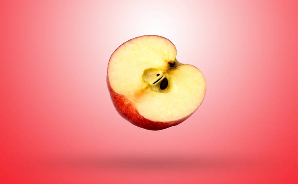 istock Red Apple cut in half isolated on gradients red and white background with clipping path 1206464879
