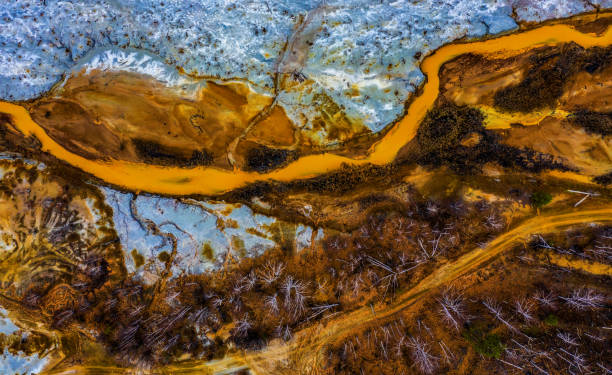 istock Aerial view drone flying forward over polluted river with destroyed ecosystem and copper tailing dump poisoning ground and water air emissions from industry environmental disaster in South Ural 1206469934