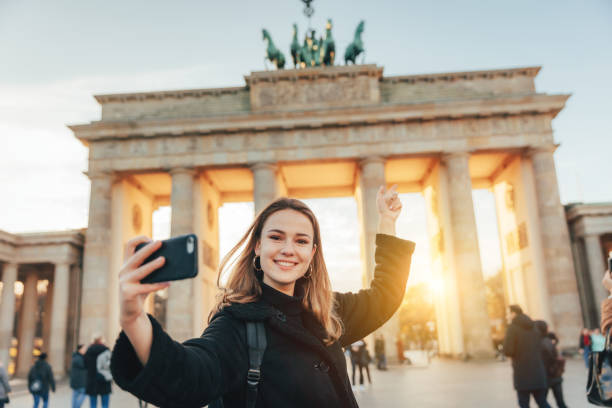joven se toma selfie en la puerta de brandeburg en berlín - berlin germany brandenburg gate germany monument fotografías e imágenes de stock