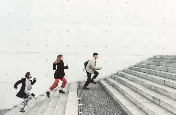 istock young friends running up steps in urban setting 1206473109