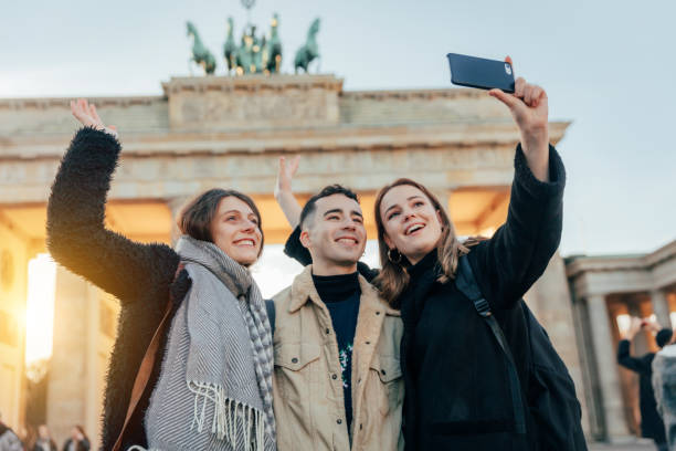 istock young Friends at Brandeburg Gate in Berlin take a selfie 1206473155
