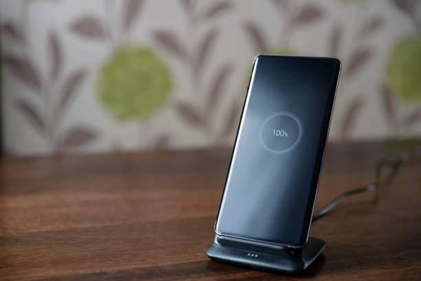 istock smartphone wireless charging on charging stand on wooden table 1206478504