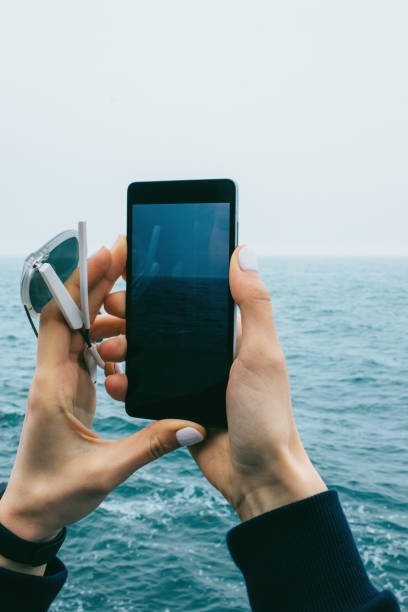 istock Close-up woman's hands photographing seascape 1206480051