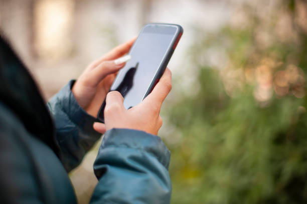 istock Close-up of hands using mobile phone in outdoor. 1206481544