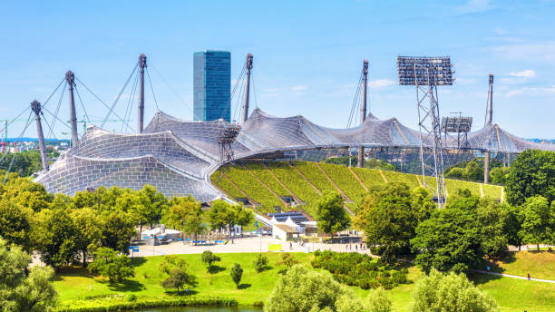 夏のオリンピア公園、ミュンヘン、ドイツ。素敵なオリンピック公園、有名なミュンヘンのランドマークの美しいパノラマビュー。ミュンヘンスタジアムの建築デザインの風景。 - roof sport competitive sport the olympic games ストックフォトと画像