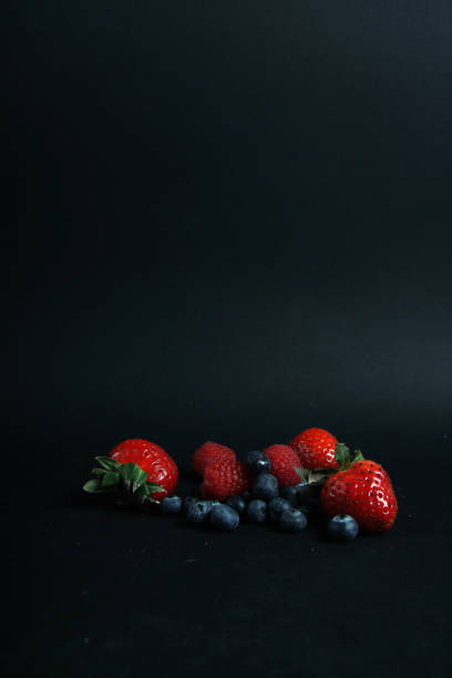 istock a pile of berries isolated on black background 1206481749
