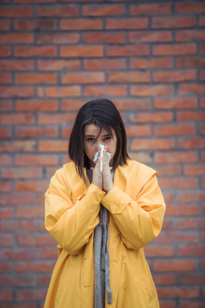 istock Sick young woman blowing her nose 1206481820