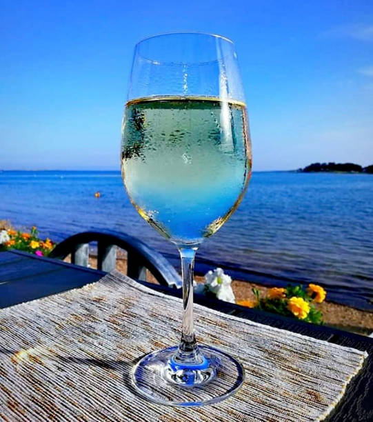istock a glass with wine near the beach 1206482514