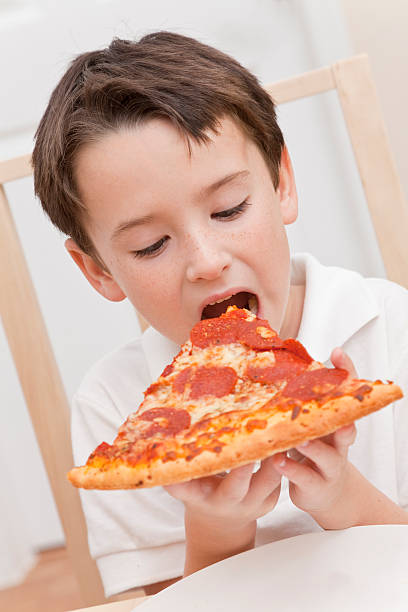 istock Young Boy Child Eating Slice of Pizza 120648307