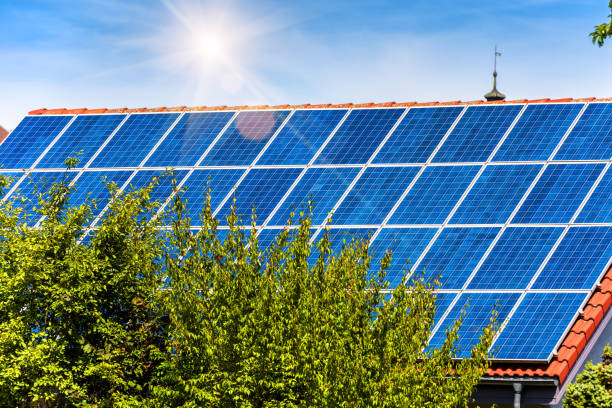 istock Solar panel on residential house rooftop. Solar system on home roof close-up. Many blue solar cells on building top for alternative energy. 1206484262