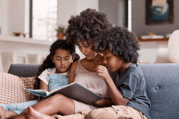 we're all getting stuck in on this story - family reading african descent book imagens e fotografias de stock
