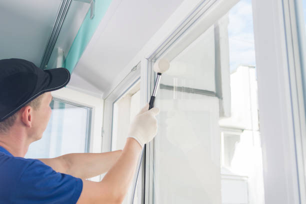 istock the master straightens the plastic window with a rubber mallet, after installing it 1206489404